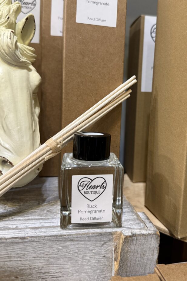 Our Black Pomegranate reed diffuser displayed on a shelf.